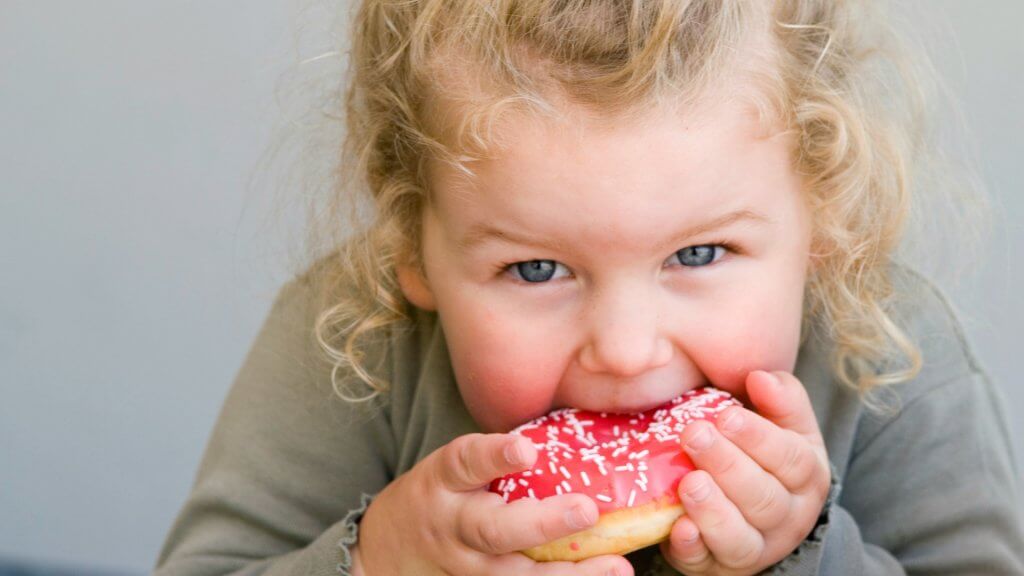девочка ест пончик