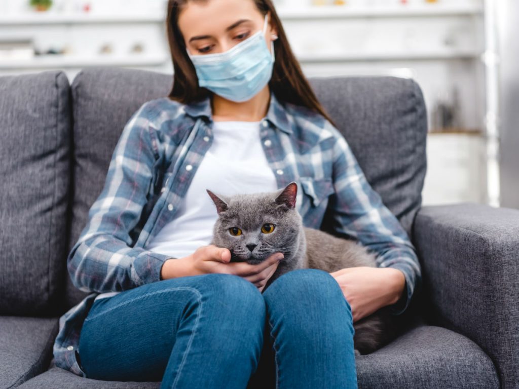 девушка в маске держит кошку