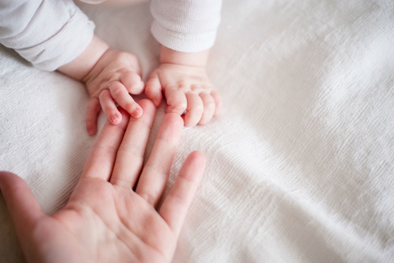 Младенец держит маму за руку