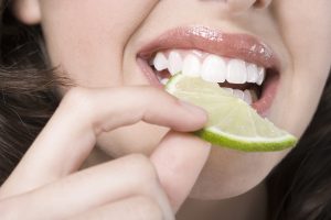 Переваривание пищи в полости рта - девушка ест лимон