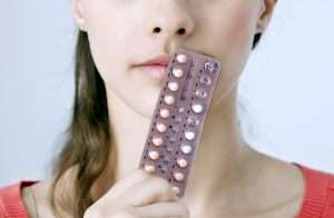 девушка пьет контрацептивы