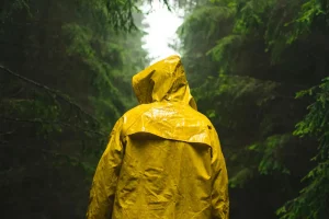 Человек в дождевике в в лесу