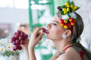Женщина кушает виноград 